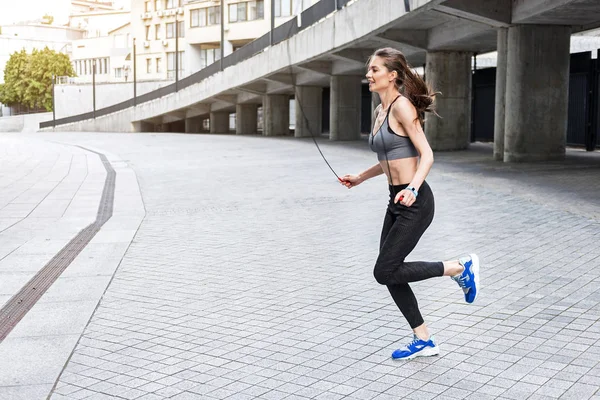 Feliz entrenamiento de mujer joven con cuerda de salto —  Fotos de Stock