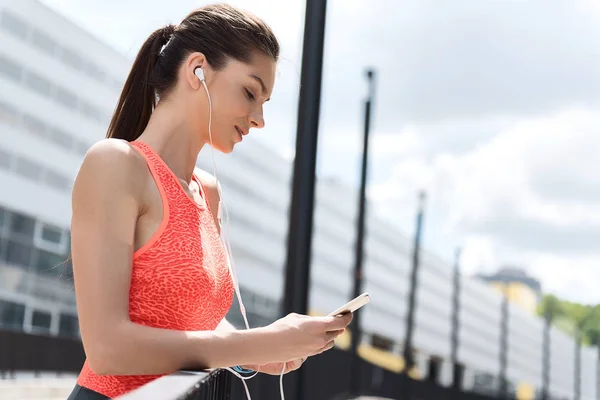 Heureuse femme mince écoutant de la musique après l'entraînement — Photo