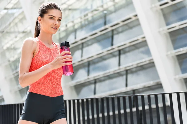 Joyeux joggeuse eau potable en plein air — Photo