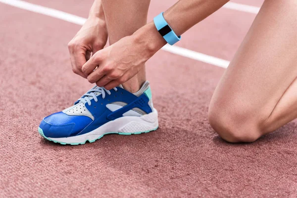 Benen voor vrouwelijke runner schoenveters op Sportschoen aanpassen — Stockfoto
