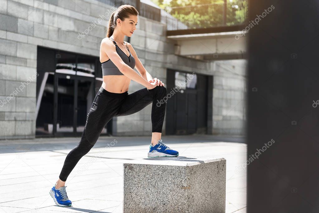 Slim young woman training near stadium