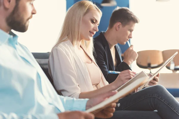 Hombres y niñas jóvenes concentrados preparándose para la entrevista de trabajo — Foto de Stock