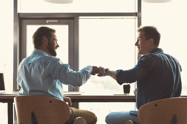 Jovens felizes cooperando juntos no trabalho no escritório — Fotografia de Stock