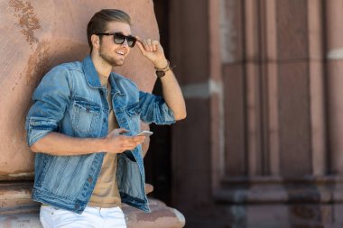 Modern cihaz açık kullanarak sakallı neşeli genç adam