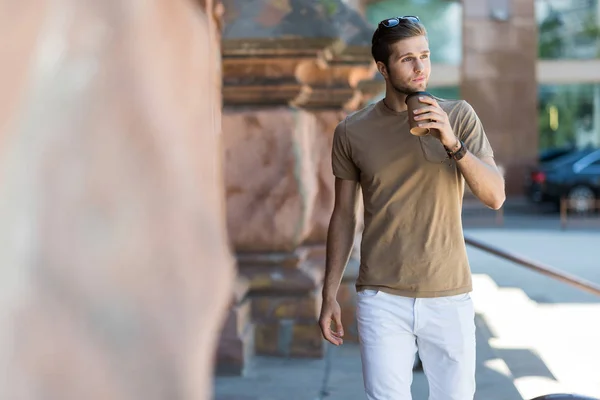 Tankeväckande ungdomlig skäggig man strosa nära stadsbyggnader — Stockfoto