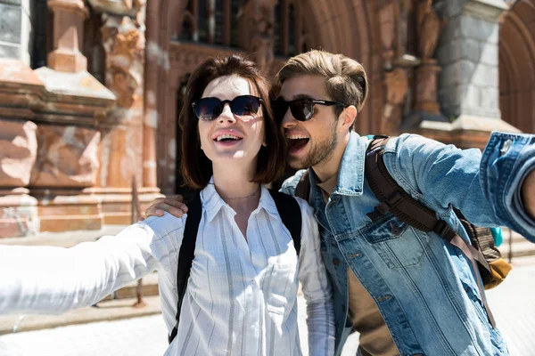 Cheery youthful woman and bearded guy having fun visiting sights — Stock Photo, Image