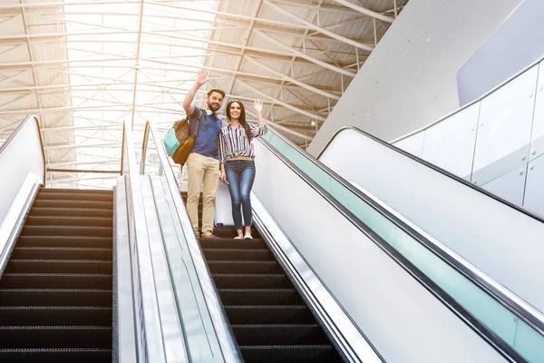 Neşeli yetişkin severler hareketli merdiven üzerinde duruyorsun