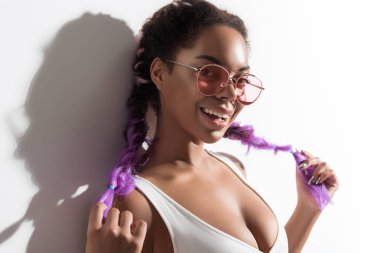 Mutlu şık genç erkek onun renkli sentetik örgüler gösterilen