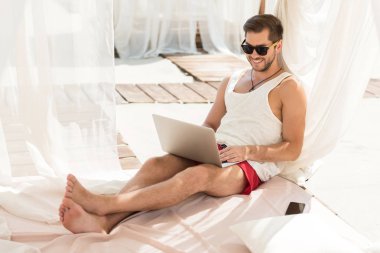 Yaz tatili Gadget'ı kullanarak sakallı neşeli genç adam