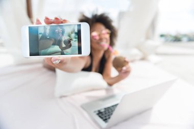Mutlu genç melez kadın plajda mobile ile eğlenceli