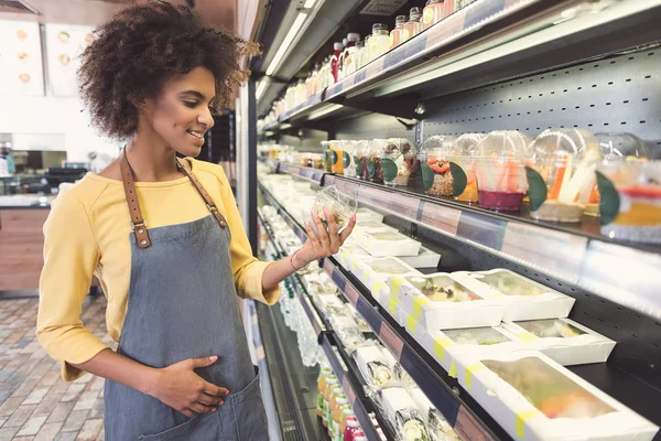 Neşeli kız önlük vejetaryen dükkanda zahmetli