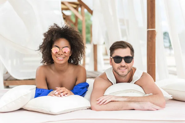 Alegre jovem casal sentindo prazer descansando na praia — Fotografia de Stock