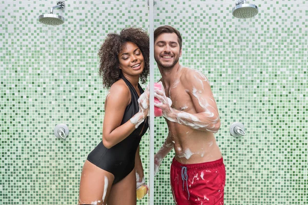 Feliz joven pareja enamorada coqueteando mientras toma ducha — Foto de Stock