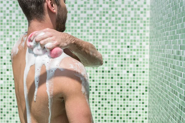 Jeugdige bebaarde man wassen in de badkamer — Stockfoto