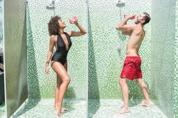 Humorística pareja juvenil divirtiéndose mientras se ducha — Foto de Stock