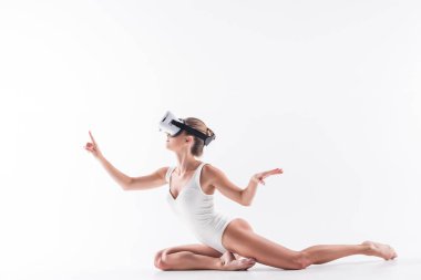 Vr headser izlerken videoda pratik kasvetli genç kadın jimnastikçi