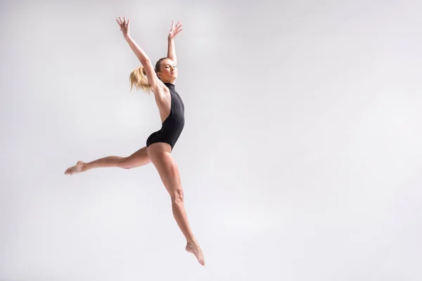 Sublime youthful lady performing gymnastics choreography jump — Stock Photo, Image