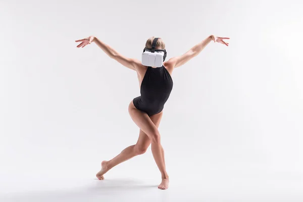 Youthful sporty woman simulating performance from video on goggles — Stock Photo, Image