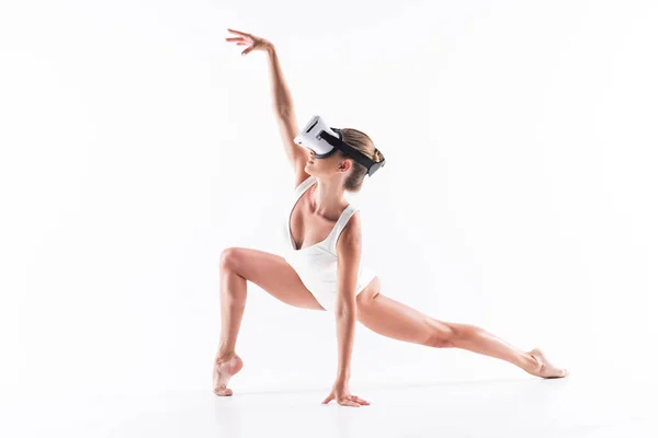 Somber youthful woman-gymnast exercising using video on goggles — Stock Photo, Image