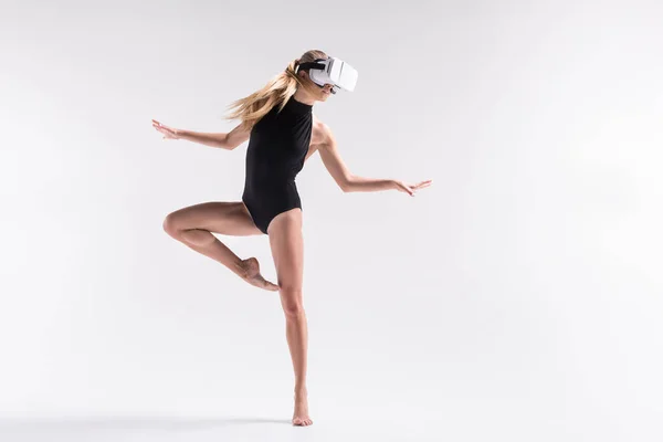 Thoughtful youthful sporty woman performing choreography using goggles — Stock Photo, Image