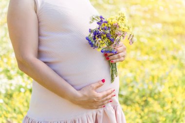 Bekleyen anne çiçek çayır üzerinde taşıyan