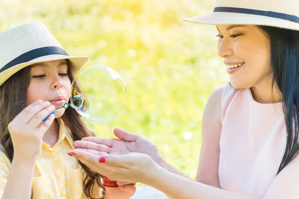 Alegre mamá y su hija jugando en los pastizales —  Fotos de Stock