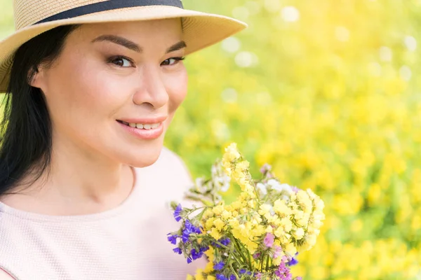 Señora alegre con flores en el prado —  Fotos de Stock