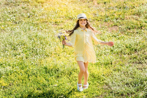 Щаслива дівчинка з букетом на луках — стокове фото