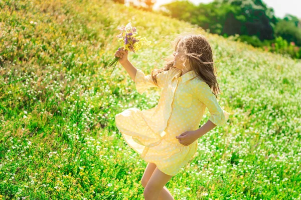 Podekscytowane dziecko kobieta gra na łąka z kwiatami — Zdjęcie stockowe