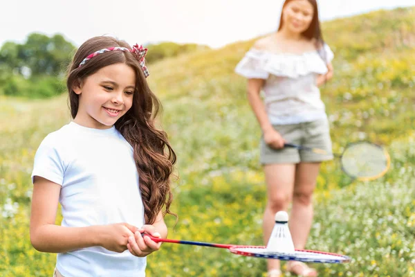 Familia alegre jugando bádminton en el prado —  Fotos de Stock