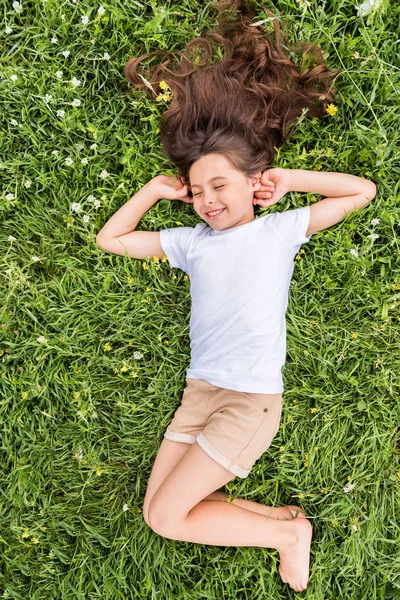 Niña feliz acostada sobre hierba verde —  Fotos de Stock