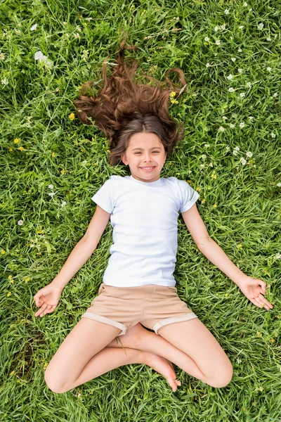 Alegre niña disfrutando de la meditación en el prado —  Fotos de Stock