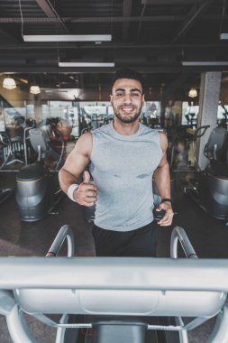 Modern bir spor salonu kardiyo yaparak giden adam