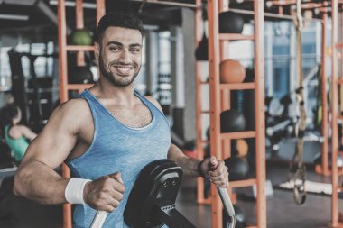 Spor salonunda egzersiz alarak giden tıraşsız adam