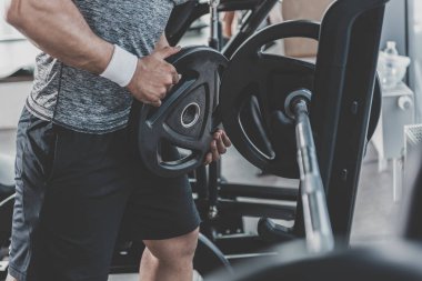 Adam koyarak ağırlık plaka üzerinde halter eller