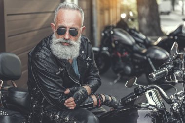 Motosiklet kullanan ciddi eski erkek kişi