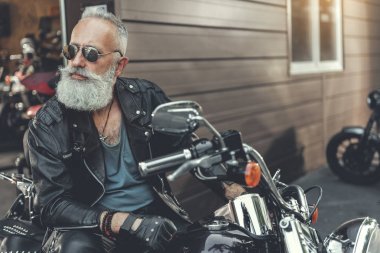 Yaşlı adam motosiklet üzerinde ciddi sakallı