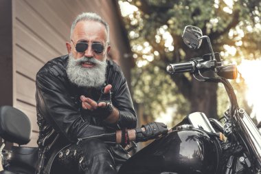 Motosiklet kullanan sevindim yaşlı erkek kişi