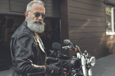 Bisiklet kask tutmak meşgul yaşlı adam