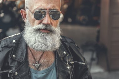 Kendine güvenen sakallı adamın garaj yanında