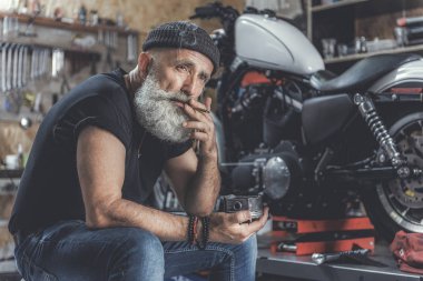 Üzgün yaşlı adam atölyede Sigara