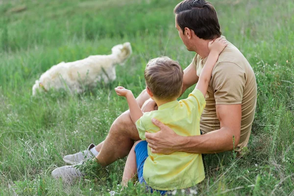Радостный отец проводит время с ребенком на лугу — стоковое фото