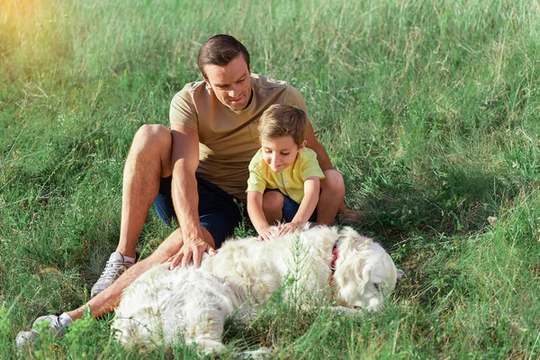 Buon padre e figlio che si divertono con il loro animale domestico — Foto Stock