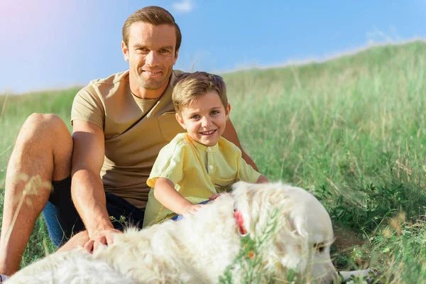 Радостная семья отдыхает на природе с собакой — стоковое фото