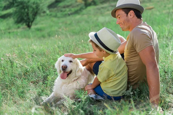 Happy parent and son stroking Labrador pet — Stock Photo, Image