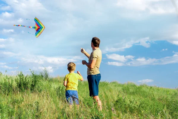 Спокойный отец развлекается со своим ребенком на травяном поле — стоковое фото