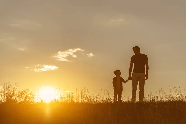 Famiglia amichevole che cammina sul campo di erba insieme — Foto Stock