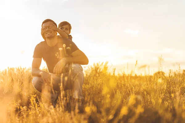 Enfant joyeux jouant avec son père sur les prairies — Photo