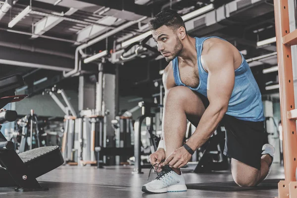 Serene hane snörning skor i gymmet — Stockfoto