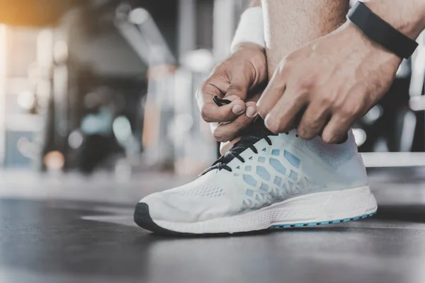 Atleet handen gelijkmakende schoenveters in sporthal — Stockfoto